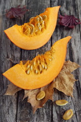 Two sliced of pumpkin on wooden background