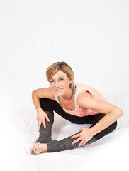 Fototapeta premium Cute woman sitting and stretching on isolated white background