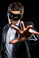 Elegant man wearing black mask posing indoors