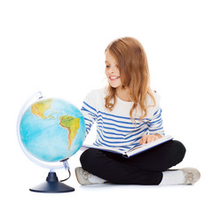 child looking at globe and holding book
