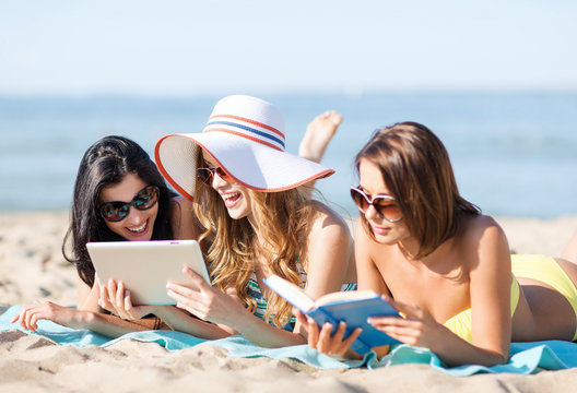 girls with tablet pc on the beach