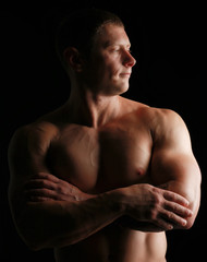 Fototapeta premium Healthy muscular young man. Isolated on black background