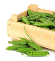 Sweet green peas in wooden box isolated on white