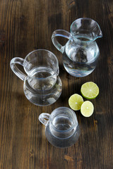 Glass pitchers of water on wooden table close-up