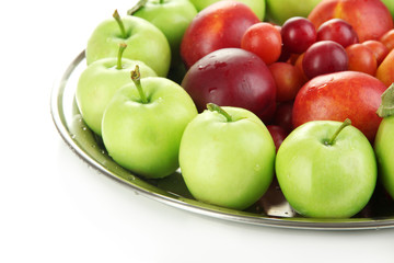 Assortment of juicy fruits on plate, isolated on white