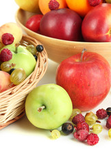 Assortment of juicy fruits in wicker basket and wooden bowl,