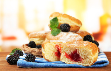 Tasty donuts with berries on wooden table