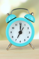 Alarm clock on table on light background