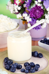 Fresh dairy products with blueberry on wooden table close-up