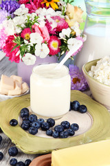 Fresh dairy products with blueberry on wooden table close-up