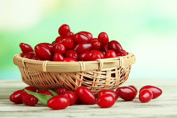 Fresh cornel berries in basket on wooden table