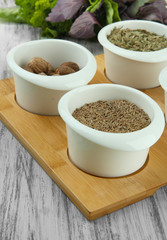 Assortment of spices in  white  bowls, on wooden background