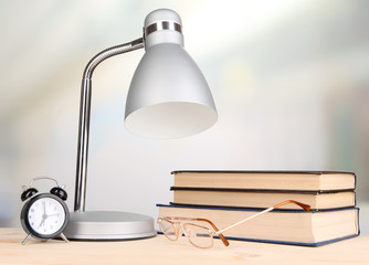 Table lamp and books on desk in room