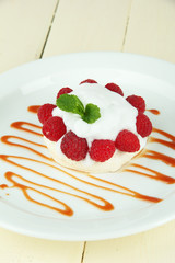 Tasty meringue cake with berries on wooden table