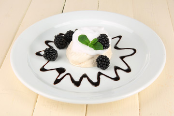 Tasty meringue cake with berries on wooden table