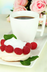 Tasty meringue cake with berries and cup of coffee,