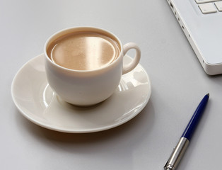 cup of coffee near the laptop