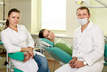 Young woman with dentist in a dental surgery.