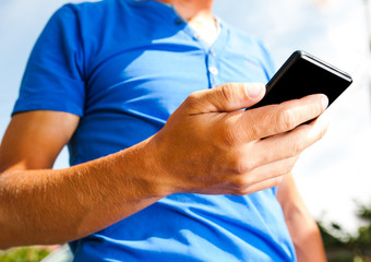 Young man using mobile smart phone, summer outdoor