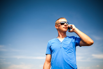 Obraz premium Young man using mobile smart phone, summer outdoor