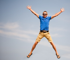 Happy man jumping, blue sky on background