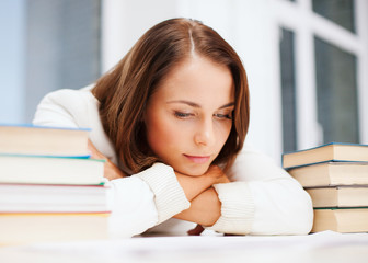 bored young woman with many books indoors