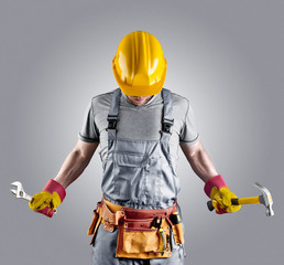 builder in a helmet with a hammer and a wrench