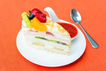 crepes cake with orange, kiwi and strawberry sauce