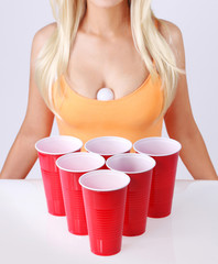 Beer pong. Red plastic cups with ping pong ball and blonde girl