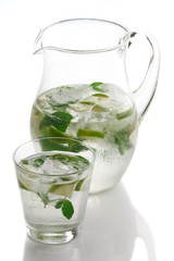 Carafe and glass of mineral water, mint,  lemon and   ice cubes