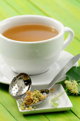 Cup of linden tea/ infusion and tea strainer