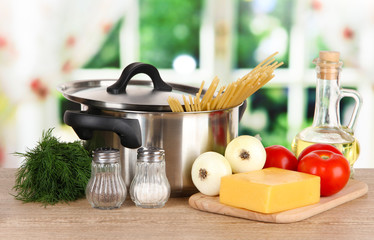 Ingredients for cooking pasta on table in kitchen