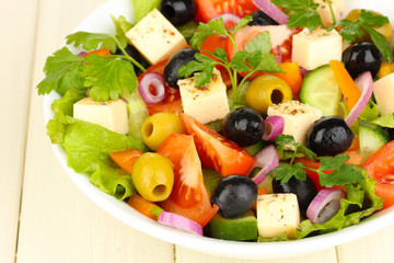 Fresh salad in plate on wooden table
