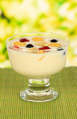 Delicious yogurt with fruit on table on bright background