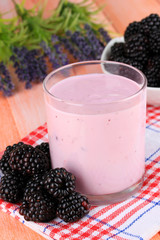 Sweet blackberries with yogurt on table close-up