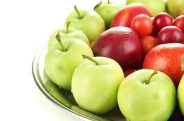 Assortment of juicy fruits on plate, isolated on white