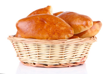 Fresh baked pasties in wicker basket, isolated on white