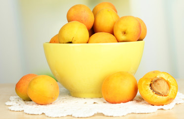 Fresh natural apricot in bowl on table in kitchen