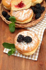 Tasty donuts with berries on wooden table