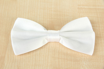 White  bow tie on wooden background