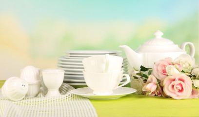 Lots beautiful dishes on wooden table on natural background