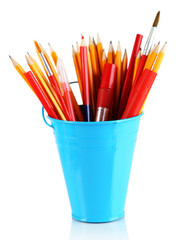 Colorful pencils and other art supplies in pail isolated