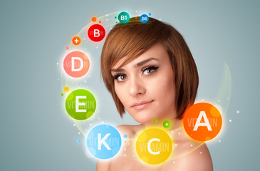 Pretty young girl with colorful vitamin icons and symbols
