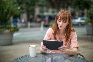 Caucasian woman using ipad tablet computer outdoor