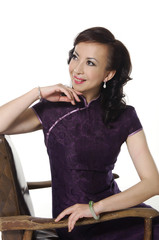 woman in the chinese national dress sitting old chair