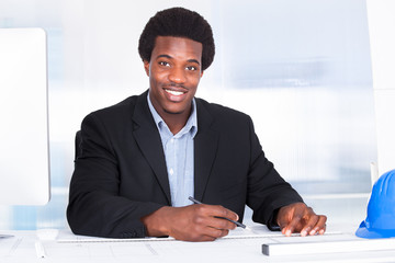Architect With Blueprint In Office