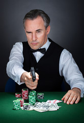 Portrait of a croupier aiming with a gun