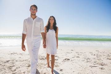 Beautiful couple holding hands and walking towards camera