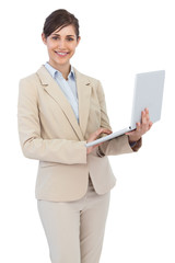 Smiling young businesswoman holding laptop