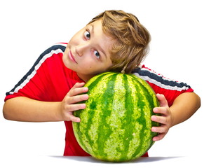 Fototapeta premium Little boy examines the maturity of watermelon